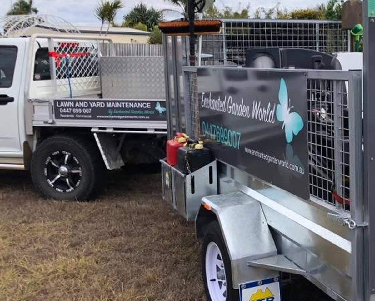 The Enchanted Garden World ute and signwritten trailer parked on a grassy block