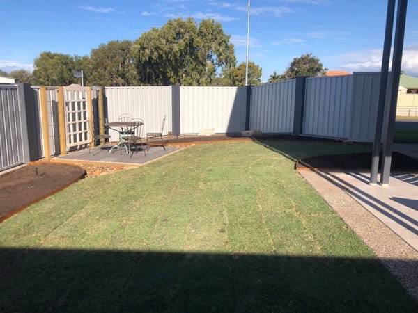 A turfed backyard with a patio and a colorbond fence
