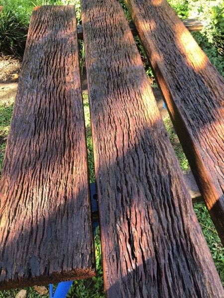 Weathered timber sleepers laid out on grass