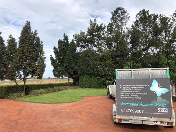 The signwritten Enchanted Garden World ute and trailer on a brick driveway